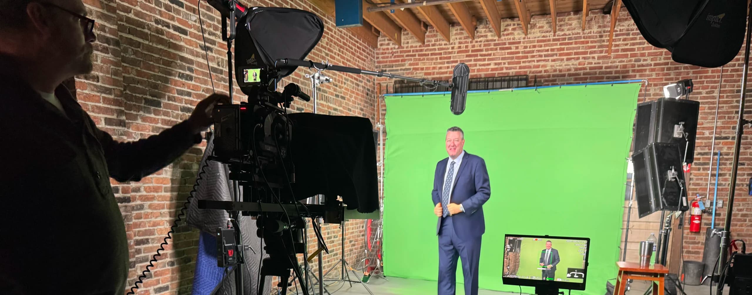 Affordable video production blog hero image of an interview in front of a green screen with video and lighting equipment